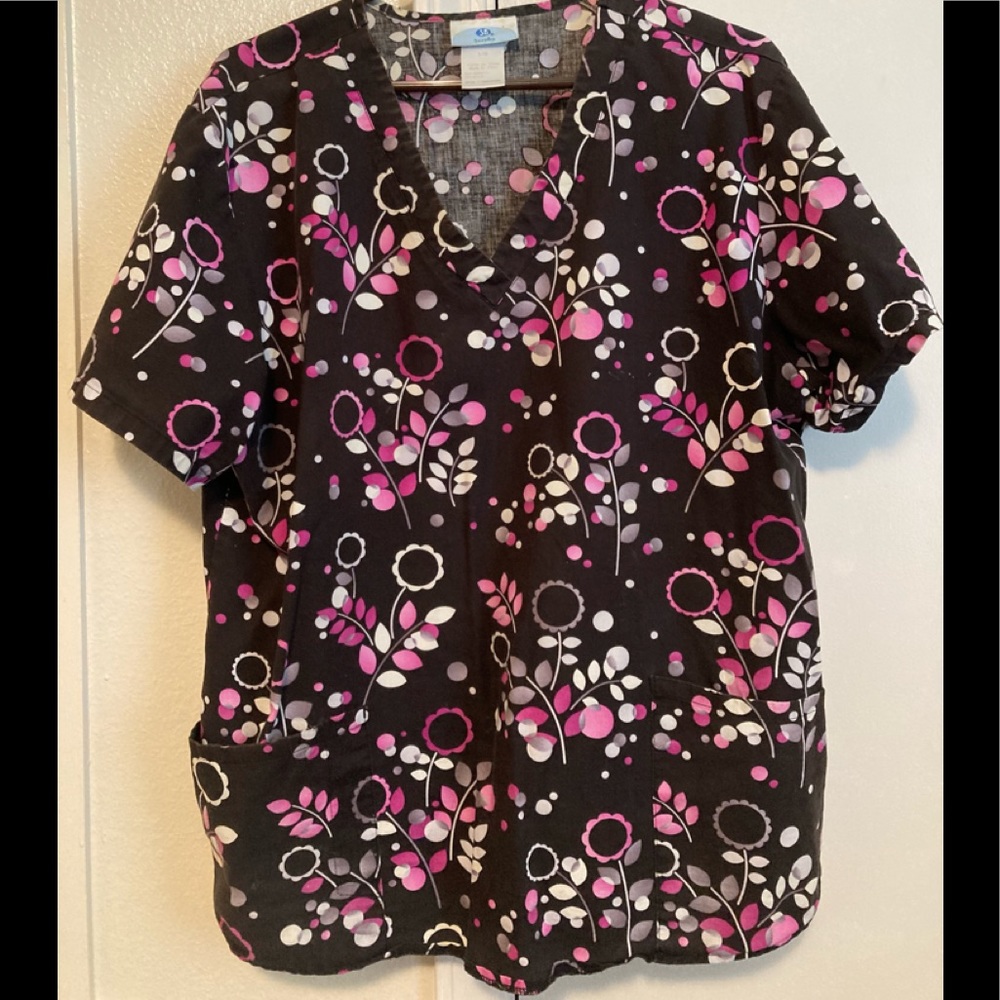 Large size Scrubs brand blouse with florals in pinks on black background.